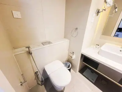 a white bathroom with a toilet and a sink at Bright And Spacious Canal View Appartment in Dubai