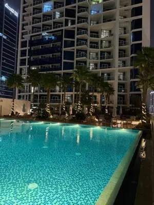 a large swimming pool in front of a large building at Bay Luxe Studio in Dubai