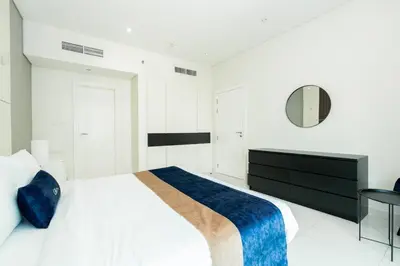 a white bedroom with a bed and a mirror at CitiHome - Elegant 1BR - Bay View - Prime Location in Dubai