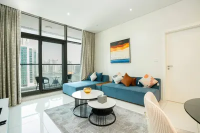 a living room with a blue couch and a table at CitiHome - Elegant 1BR - Bay View - Prime Location in Dubai