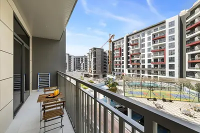 a balcony with a view of a city with buildings at Stylish 1BR with PS5, Sauna and Kids' Play Area in Dubai