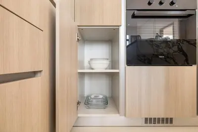 a cupboard with a bowl and a bowl at Stylish 1BR with PS5, Sauna and Kids' Play Area in Dubai