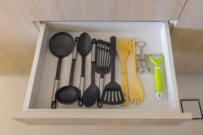 a drawer filled with cooking utensils and spatulas at Stylish 1BR with PS5, Sauna and Kids' Play Area in Dubai