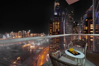 a balcony with a view of a city at night at Marina 2BR with 31st-Floor Ocean View in Dubai