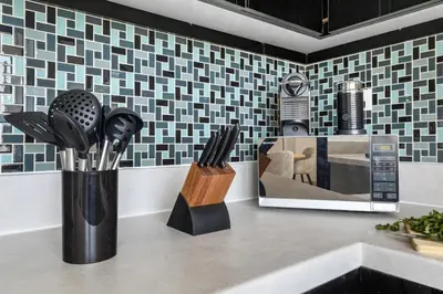 a kitchen counter with a microwave and utensils at Marina 2BR with 31st-Floor Ocean View in Dubai
