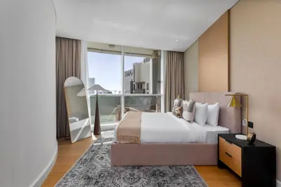 a bedroom with a large bed and a large window at Maison Privee - Dazzling Downtown Retreat with Panoramic City Views in Dubai