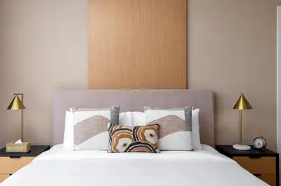 a bedroom with a large white bed with two lamps at Maison Privee - Dazzling Downtown Retreat with Panoramic City Views in Dubai