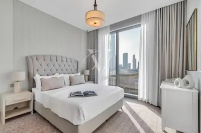 a white bedroom with a bed and a large window at 3BR in Vida Dubai Mall with Stunning Burj Khalifa View in Dubai