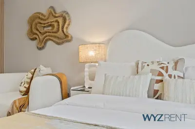 a bedroom with a white bed and a chair at Newly Listed Airy Boho Studio Azizi Riviera 26 in Dubai