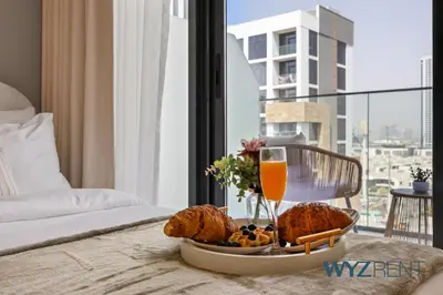 a tray of food and a glass of orange juice at Newly Listed Airy Boho Studio Azizi Riviera 26 in Dubai