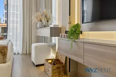 a living room with a tv on a wall at Newly Listed Airy Boho Studio Azizi Riviera 26 in Dubai