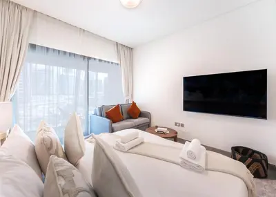 a living room with two beds and a large window at Brand New Studio for 4 Guests - Near Dubai Mall in Dubai