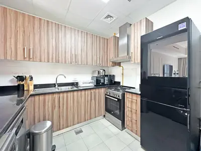a kitchen with black appliances and wooden cabinets at Luxury Stay in Downtown Dubai -Burj Khalifa in Dubai