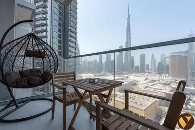 a balcony with a hammock and a table and chairs at Vogue Downtown Vida Dubai Mall, Direct Access to Dubai Mall via Climate Controlled bridge, Two Bedroom Apartment with Full Burj Khalifa View from Balcony and Access to all Amenities in Dubai