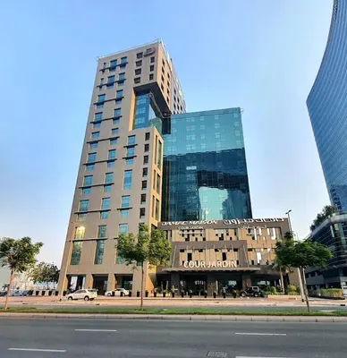 a tall building with a car parked in front of it at DAMAC Maison Cour Jardin in Dubai