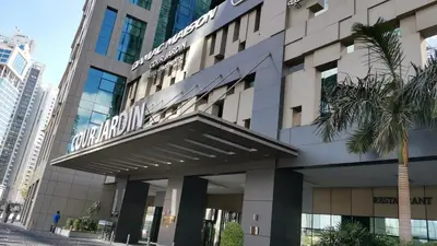 a building with a sign on the front of it at DAMAC Maison Cour Jardin in Dubai