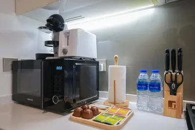 a microwave sitting on a kitchen counter with bottles of water at EasyGo - Bright Studios in The Heart of Business Bay in Dubai