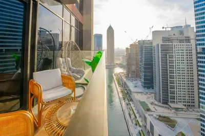 a balcony with a chair and a view of a city at EasyGo - Bright Studios in The Heart of Business Bay in Dubai