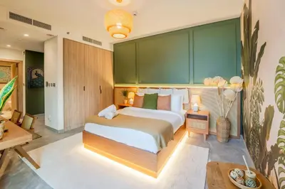 a bedroom with a large bed with a green wall at EasyGo - Bright Studios in The Heart of Business Bay in Dubai