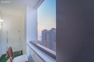 a room with a window with a view of a city at 4BR Spacious Apartment in Sadaf 8 JBR, 3 Min Walk To The Beach With Sea and Dubai Marina View in Dubai