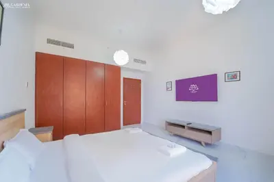 a bedroom with a large bed and a tv at 4BR Spacious Apartment in Sadaf 8 JBR, 3 Min Walk To The Beach With Sea and Dubai Marina View in Dubai