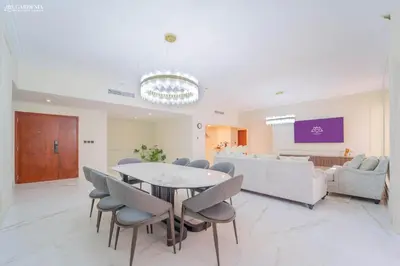 a living room with a table and chairs and a couch at 4BR Spacious Apartment in Sadaf 8 JBR, 3 Min Walk To The Beach With Sea and Dubai Marina View in Dubai