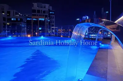 a swimming pool at night with a water fountain at Studio for 4 just 5 Min Walk to Burj Khalifa, Downtown Dubai, Tower Elite 1 in Dubai
