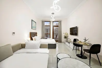 a living room with a couch and a bed and a table at FIRST CLASS High End Studio near Miracle Garden in Dubai