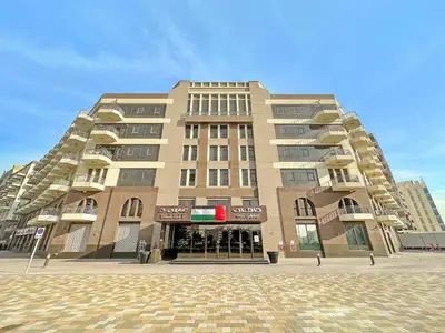 a large building in front of a building at FIRST CLASS High End Studio near Miracle Garden in Dubai