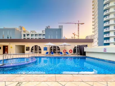 a swimming pool on the roof of a building at FIRST CLASS High End Studio near Miracle Garden in Dubai