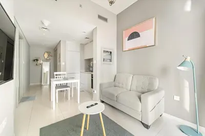 a living room with a couch and a table at Stylish 1BR w/ Pool View | Heart of Business Bay in Dubai