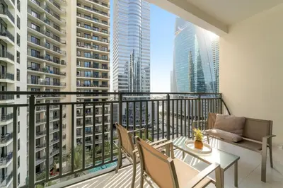 a balcony with a table and chairs and buildings at Stylish 1BR w/ Pool View | Heart of Business Bay in Dubai
