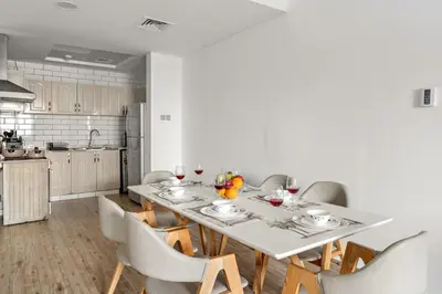 a dining room with a table and chairs and a kitchen at FIRST CLASS 1BR Stylish Escape , Near Metro in Dubai