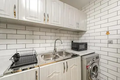 a kitchen with a sink and a washing machine at FIRST CLASS 1BR Stylish Escape , Near Metro in Dubai
