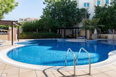 a large swimming pool with blue water in a building at FIRST CLASS 1BR Stylish Escape , Near Metro in Dubai