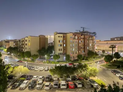 a parking lot with cars parked in front of buildings at FIRST CLASS 1BR Stylish Escape , Near Metro in Dubai