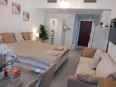 a living room with a large bed and a couch at Dubai Marina Apartment in Dubai