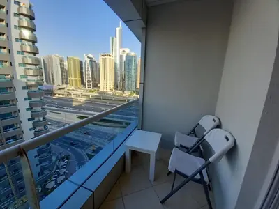 a balcony with a desk and chair on a building at Dubai Marina Apartment in Dubai