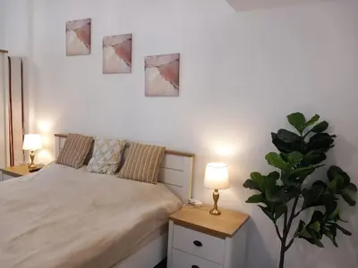 a bedroom with a bed and two lamps and a plant at Dubai Marina Apartment in Dubai
