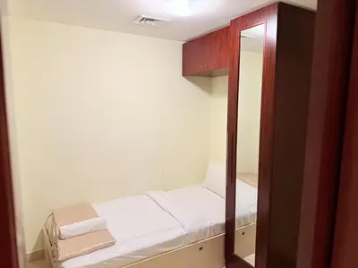 a small room with a bed and a mirror at Elegant 2BR Beach Apartment Grandeur Residence, Palm Jumeirah in Dubai