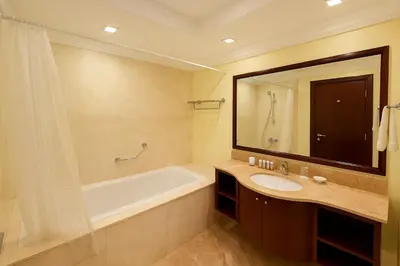 a bathroom with a tub and a sink and a mirror at Elegant 2BR Beach Apartment Grandeur Residence, Palm Jumeirah in Dubai