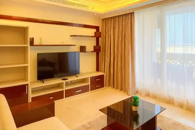 a living room with a tv and a couch and a table at Elegant 2BR Beach Apartment Grandeur Residence, Palm Jumeirah in Dubai