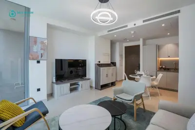 a living room with a couch and a table and chairs at Blue Breeze - Luxury 2BR in Sobha Creek Vistas Near Downtown in Dubai