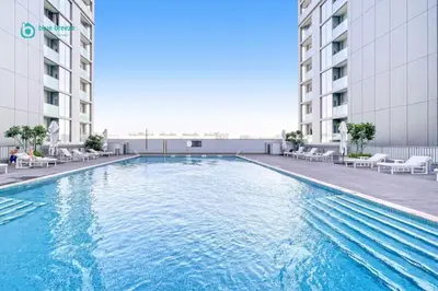 a large swimming pool in the middle of a building at Blue Breeze - Luxury 2BR in Sobha Creek Vistas Near Downtown in Dubai