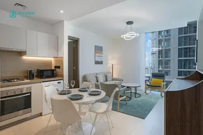 a kitchen and living room with a table and chairs at Blue Breeze - Luxury 2BR in Sobha Creek Vistas Near Downtown in Dubai