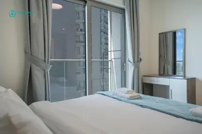 a bedroom with a bed and a large window at Blue Breeze - Luxury 2BR in Sobha Creek Vistas Near Downtown in Dubai