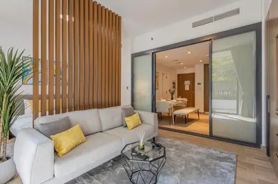 a living room with a couch and a table at Hamilton House, JVC - 1 Bedroom Apartment - Allsopp & Allsopp in Dubai