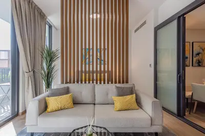 a living room with a couch with yellow pillows at Hamilton House, JVC - 1 Bedroom Apartment - Allsopp & Allsopp in Dubai
