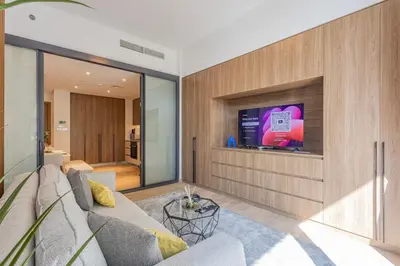 a living room with a couch and a tv at Hamilton House, JVC - 1 Bedroom Apartment - Allsopp & Allsopp in Dubai