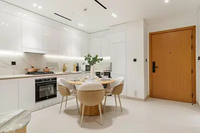 a kitchen with a table and chairs in a kitchen at FIRST CLASS 1BR Luxurious JVC Blissful Escape in Dubai
